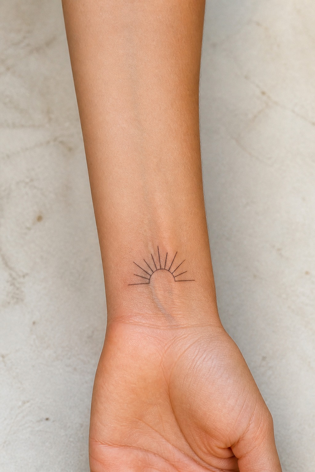 Minimalist line art sunburst forearm tattoo