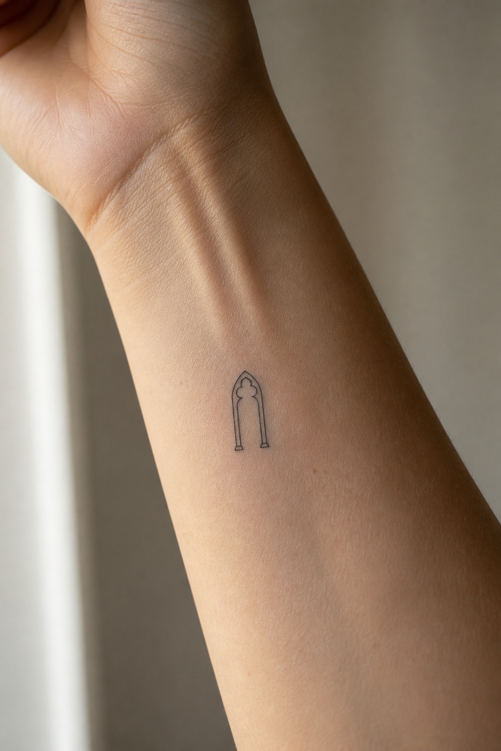 Micro gothic arch wrist tattoo
