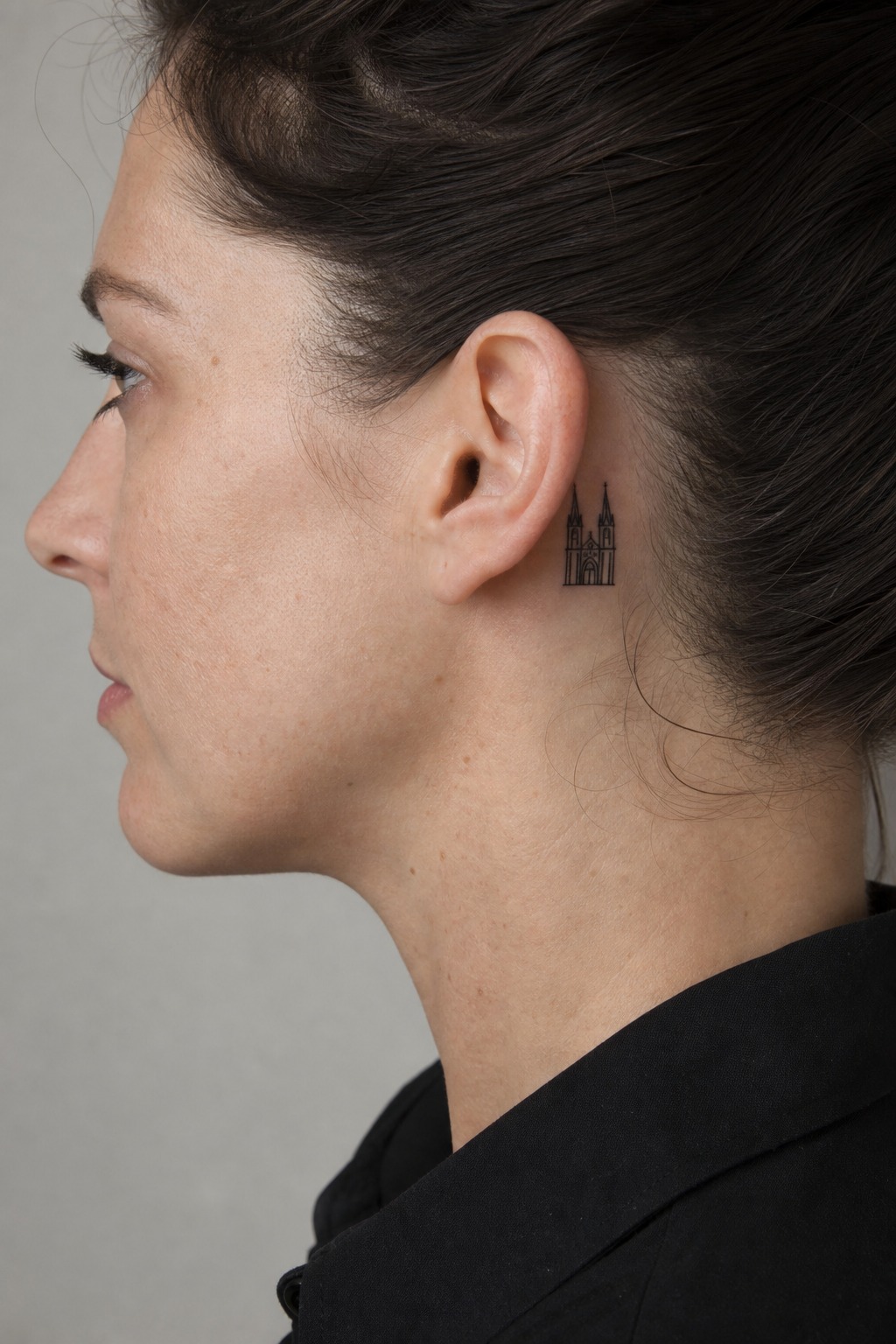 Minimalist cathedral silhouette behind the ear tattoo