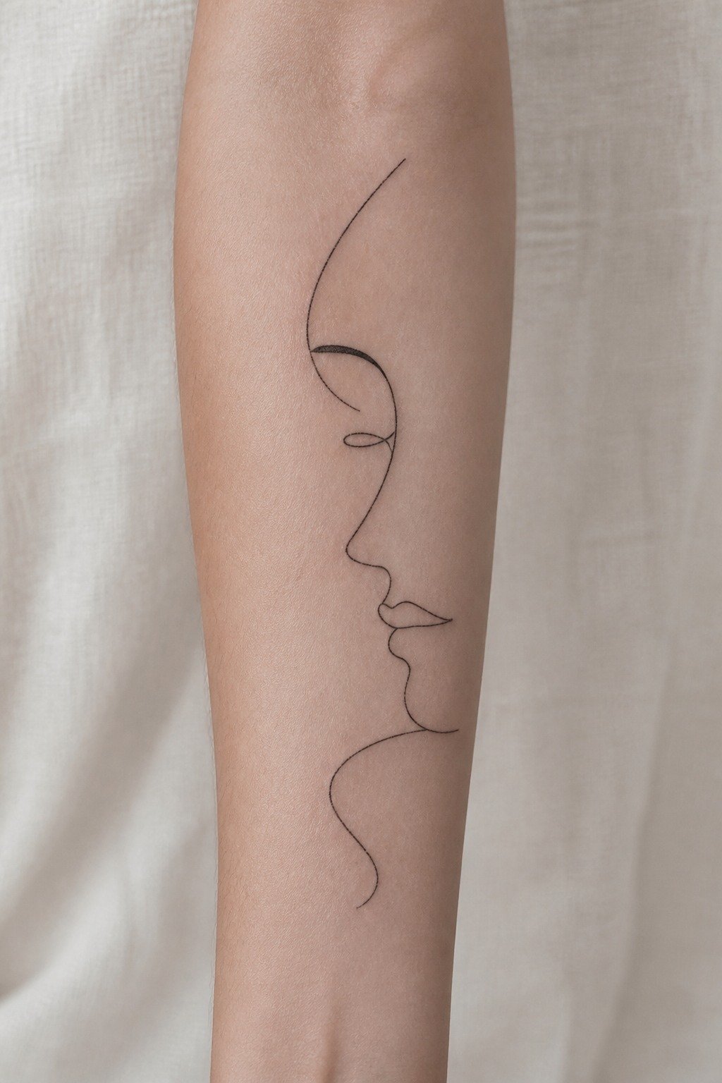 Abstract single line face drawing forearm tattoo