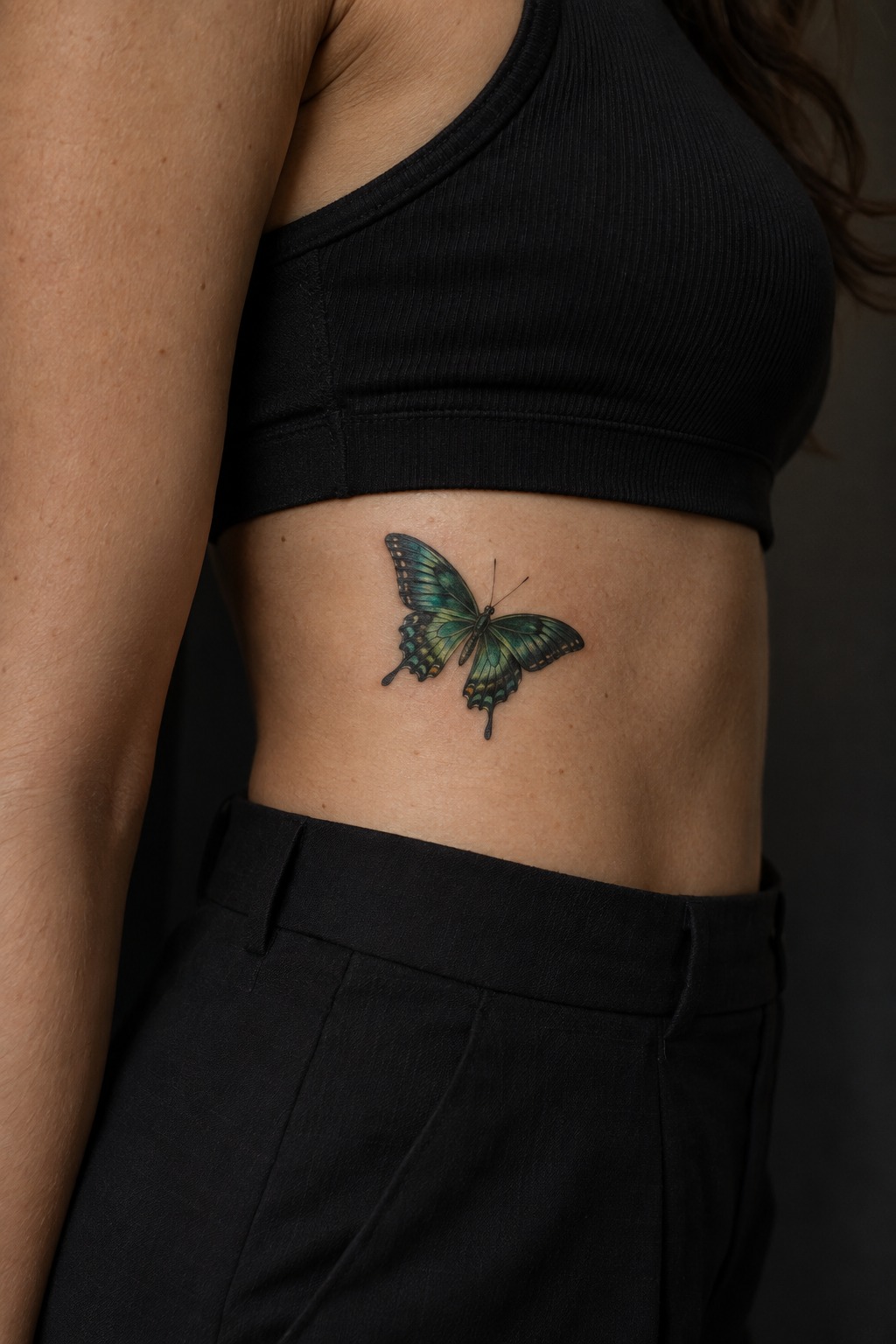 Micro realism emerald butterfly rib accent tattoo