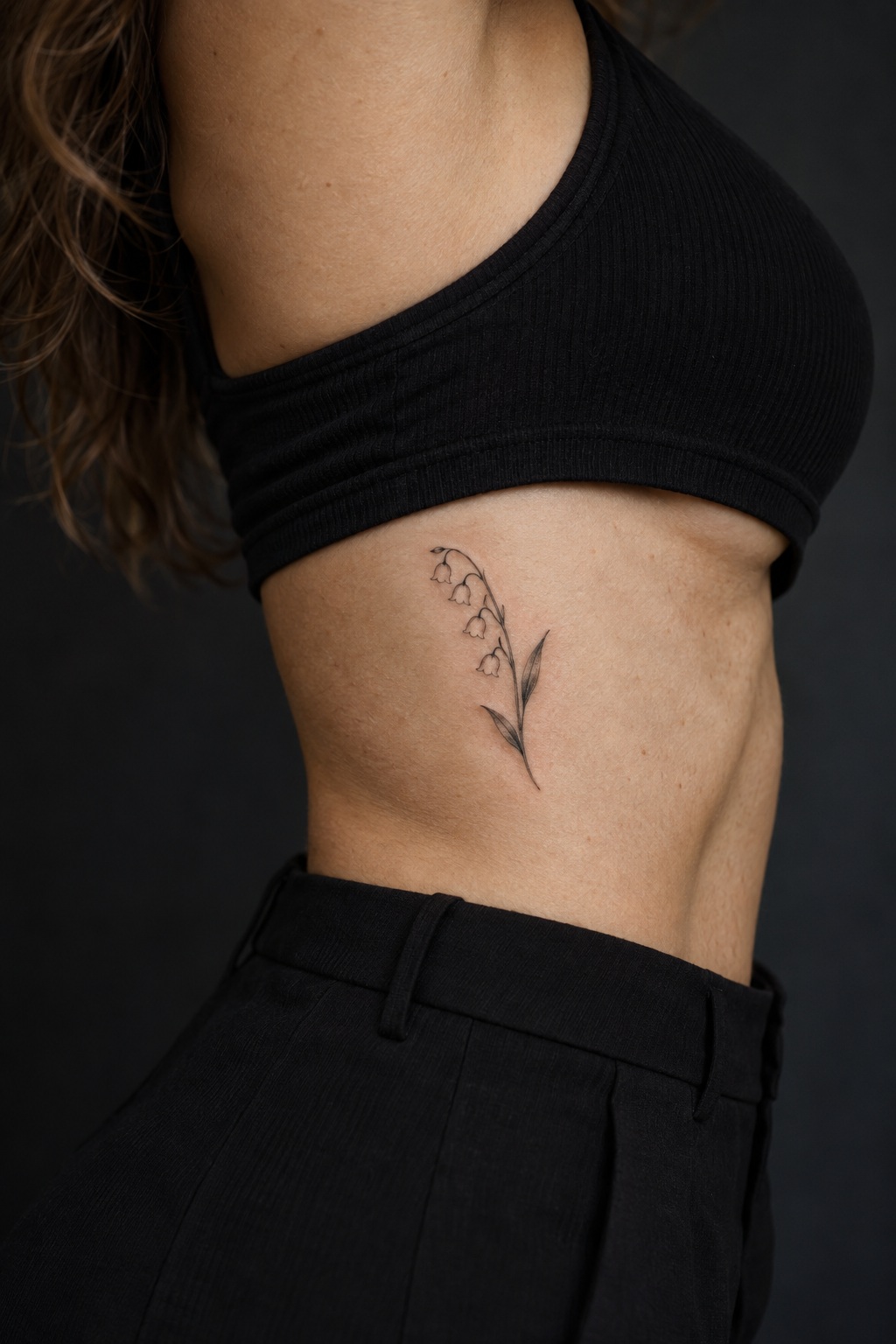 Micro lily of the valley rib accent tattoo